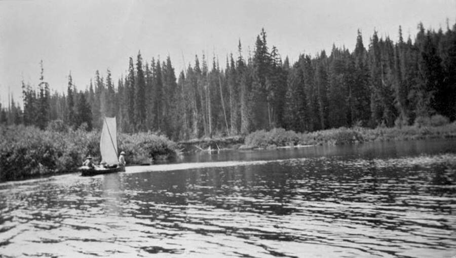 People in a sail boat going down the Thorofare River. Donated by Stan McClung through Priest Lake Museum.