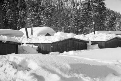 Snow burried houses in a logging camp. Donated by Speed Weidner through Priest Lake Museum.