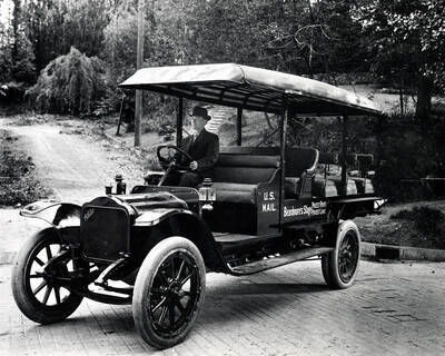 A man sits behind the wheel of the Beardmore Auto Stage. Priest River, Idaho.