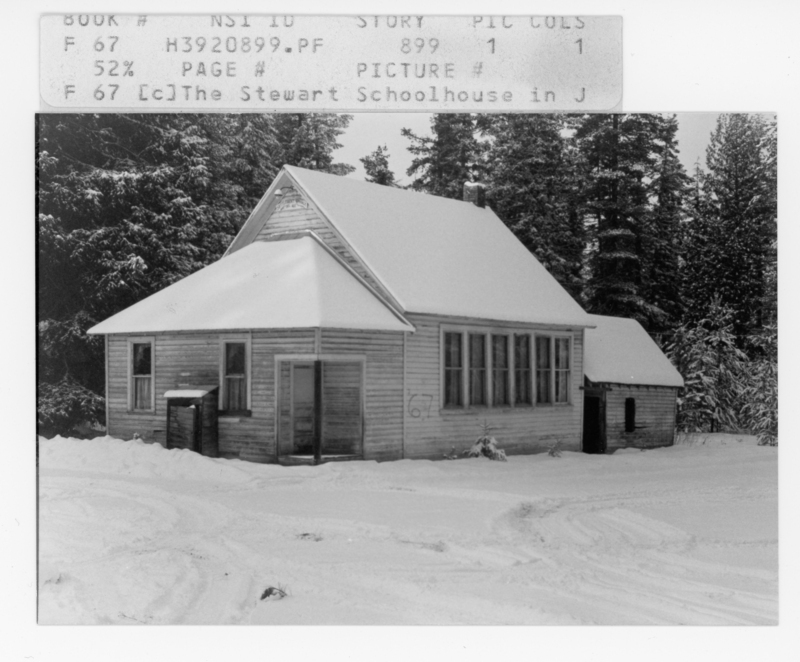 A small wooden house with a steep roof, covered in snow, is surrounded by tall trees. The building has multiple windows and a small attached shed at the back. Snow covers the ground and the branches of the trees. Top label reads: - "BOOK # NS 10 STORY PIC COLS" - "F 67 H3920899.PF 899 1 1" - "52% PAGE # PICTURE #" - "F 67 [c]The Stewart Schoolhouse in J" - On the building: - "67"