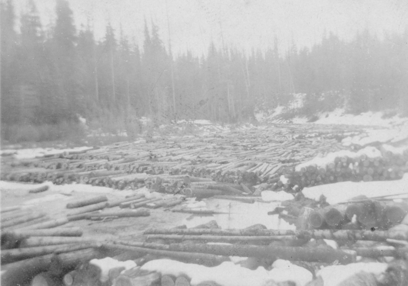 A faded photo of a log jam on a river.