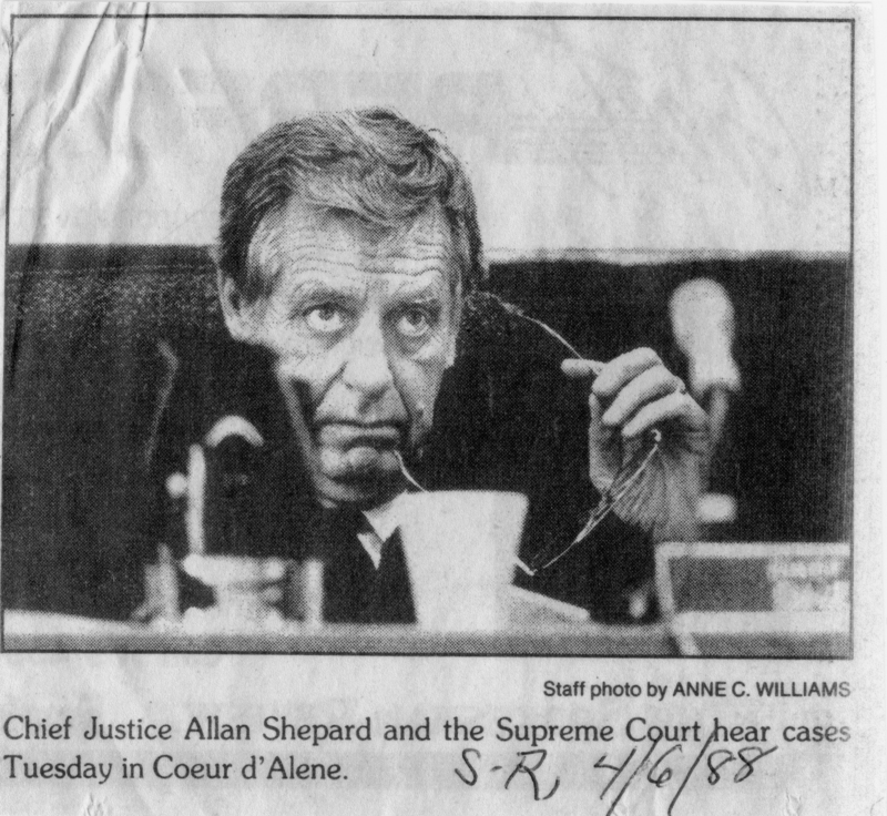 A man in formal attire sits behind a desk, holding his glasses in one hand, with a focused expression. There is a cup and a microphone on the desk in front of him. Label near the bottom left reads: "Chief Justice Allan Shepard and the Supreme Court hear cases Tuesday in Coeur d'Alene." Text near the bottom right reads: "Staff photo by ANNE C. WILLIAMS." Handwritten text near the bottom right reads: "S-R 4/6/88."