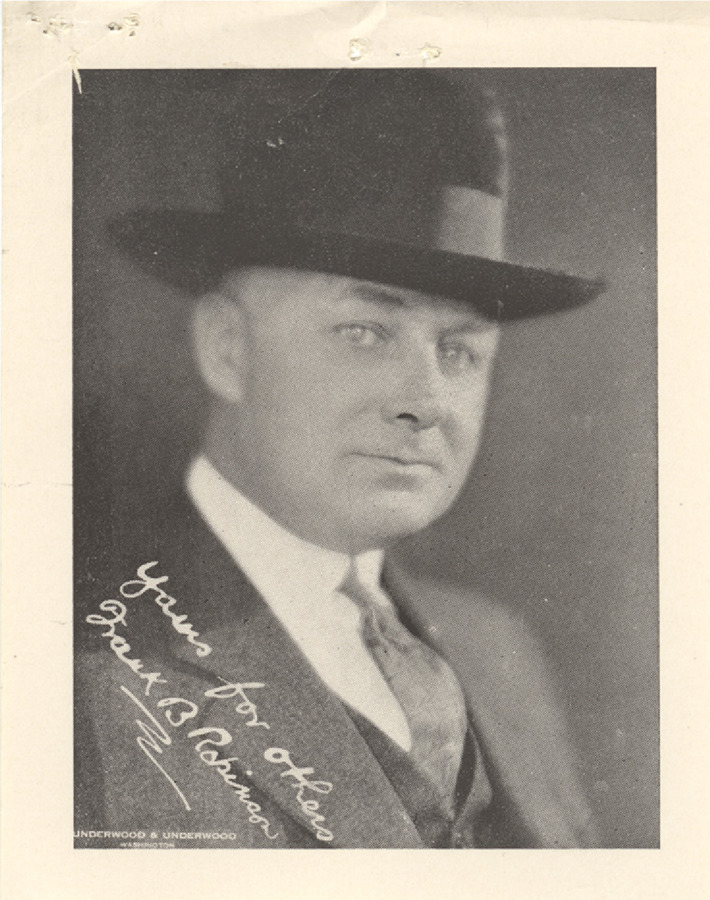 Sepia photograph of Robinson in a hat and suit. Also includes an autograph and note reading, 'Yours for Others, Frank B. Robinson.'