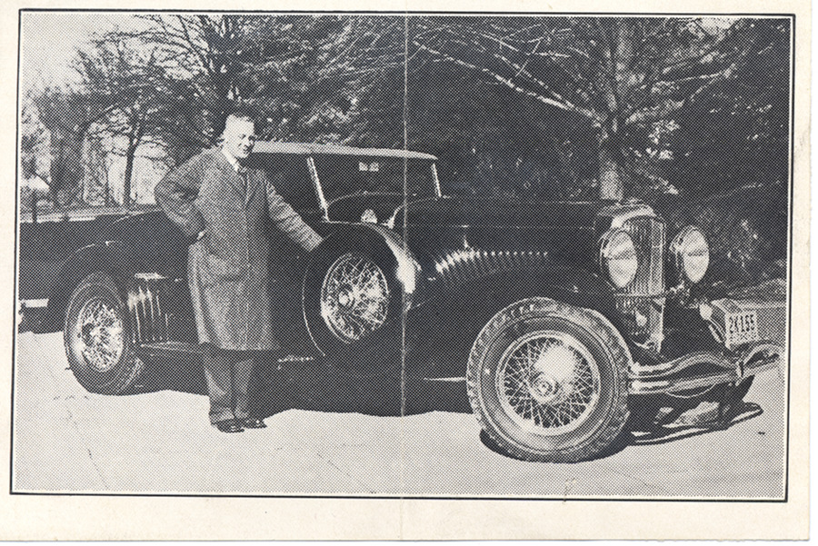 Newspaper clipping of a photograph of Frank B. Robinson standing in front of his Duesenberg Convertible Coupe.