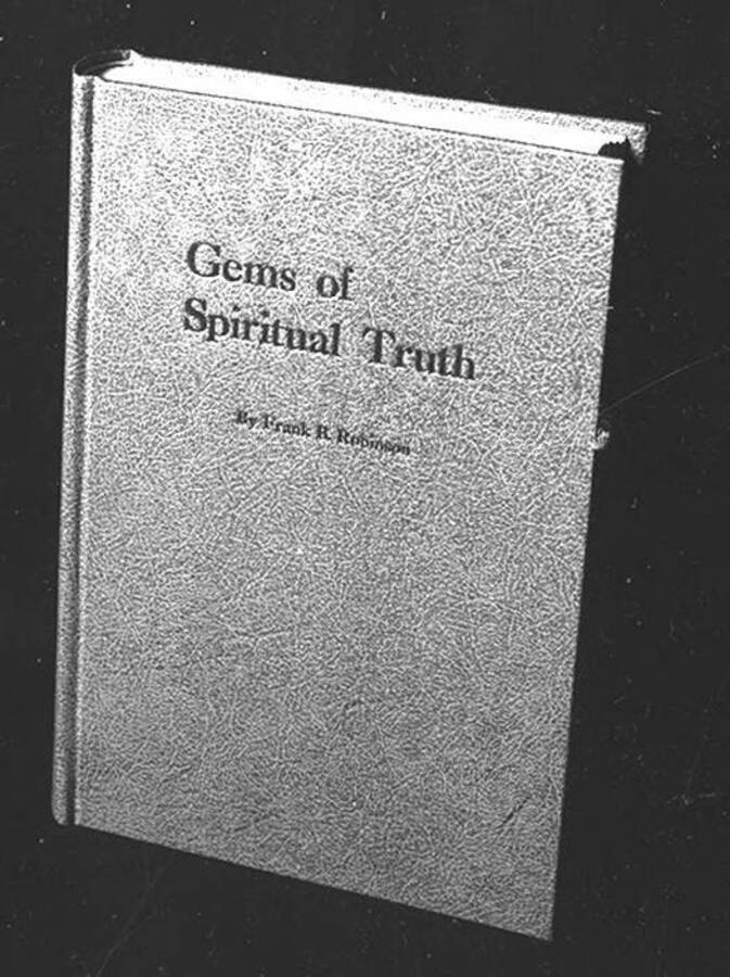 Negative photograph of the cover of Frank B. Robinson's book in hardback with only the text 'Gems of Spiritual Truth' with each letter pronounced in sunken relief.