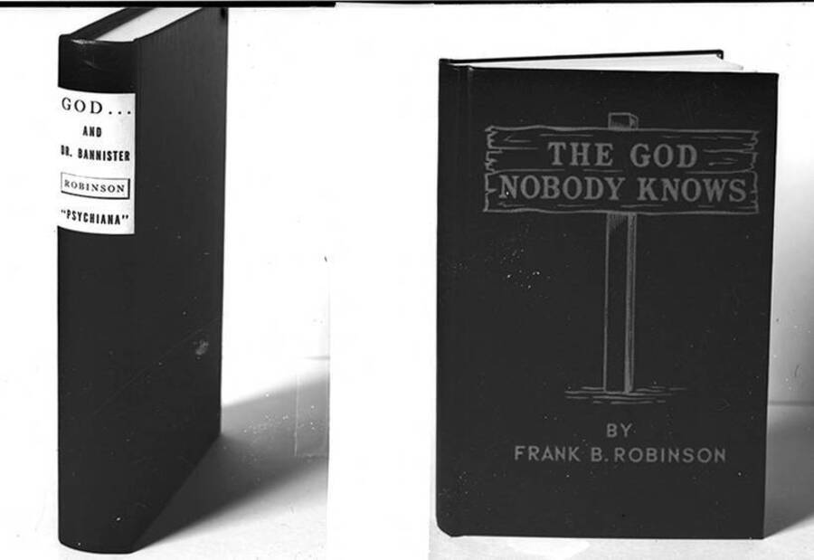 Negative photograph of the cover and spine of Frank B. Robinson's book The God Nobody Knows. The cover includes  a drawing of a wooden sign in the ground that reads the book's title.