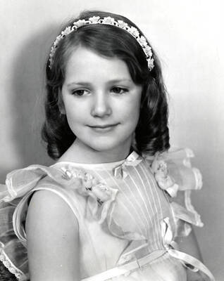 Portrait depicts Florence Robinson, child, wearing a dress and decorative headband.