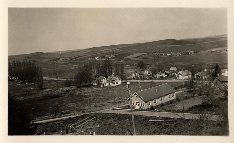 Wood conversion lab (Center right), houses and fields in background. There is a man on a tree or telephone pole stringing lines, maybe for electricity? 'Ergr Day' written on back.