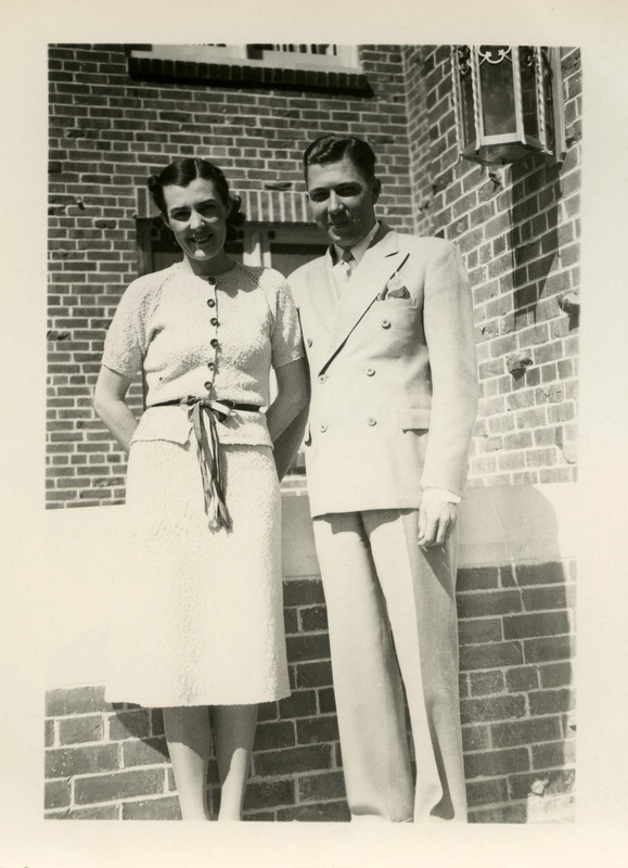 Dr. and Mrs. Irvin Jolley Christman Hall Proctor and Hostess, standing outside in front of a brick building. Dr. Jolley is also a Chemistry professor for the University of Idaho.