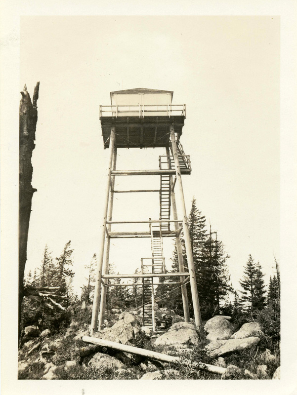 Old Moscow Mountain lookout tower on top of a rocky, forested hill.