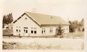Looking northwest at the Wood Conversion lab (Center) from a field across the street. A man is standing in front of the door.