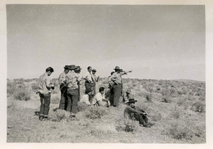 Dr. V. A. Young on a range trip, pointing off into the distance while students are standing or sitting, taking notes.