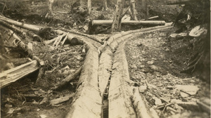 Two log flumes converging into one in the Coeur d'Alene National Forest. Timber debris surrounds the flumes.