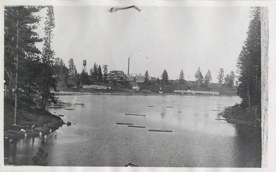 Winchester Lake and mill in background. Winchester Lake was a man-made lake for the mill's operation. People pictured swimming in the lake.