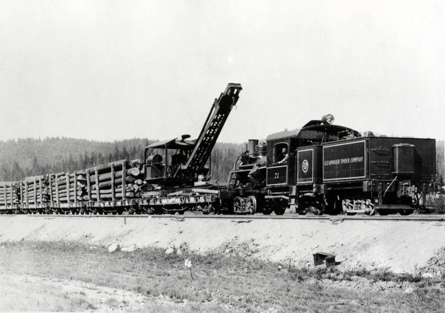 A photograph of a Clearwater Timber Co. Train Engine transporting a large amount of lumber.