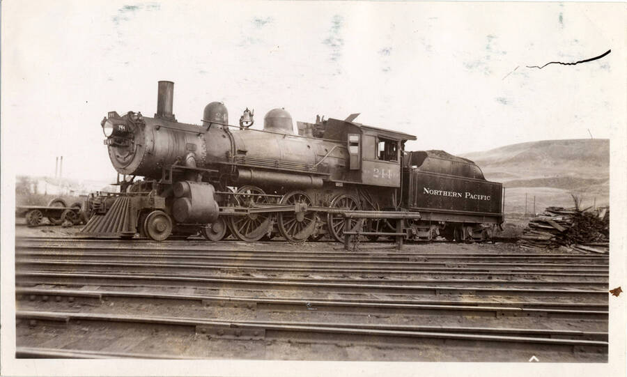 A photograph of Northern Pacific Train Engine 244 sitting stationary in a train yard.