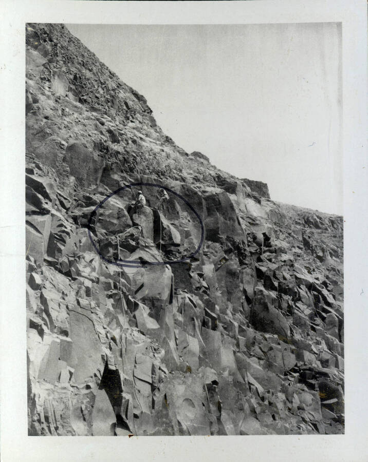 Photograph of men scaling the bank of steep rock fixtures in preparation for rock removal at Purringron-Schultz Bar in Wawawai.