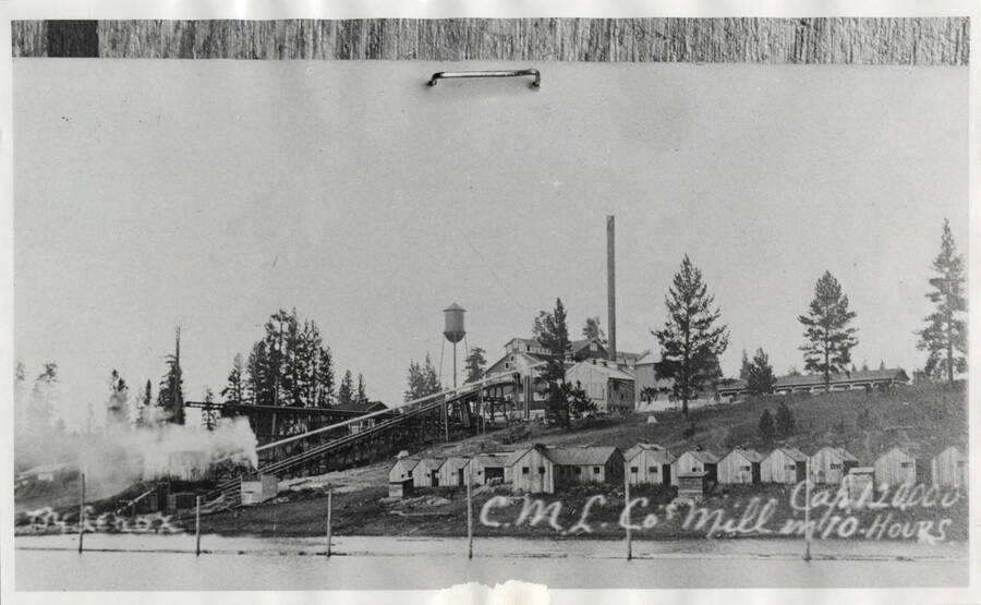 Craig Mountain Lumber Mill, Winchester, Idaho. Pictured on the side of a man-made lake in operation with an active smokestack.