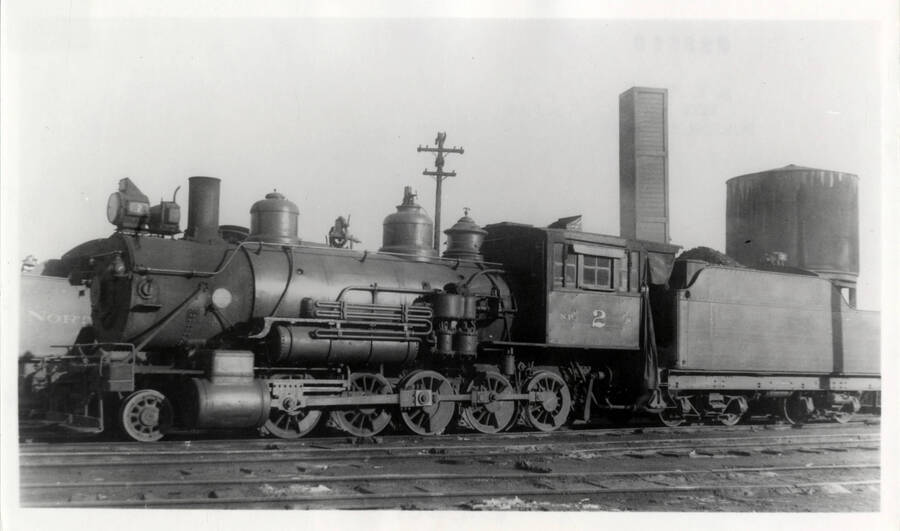 Northern Pacific Decapod Engine No. 2, stationary at a train yard. Northern Pacific had only two Decapods; they were the largest engines in the world when built by Baldwin in 1886 for service over the Cascades before completion of the Stampede tunnel. Originally numbered 500 and 501, they were renumbered to 1 and 2 in 1896. Both were assigned to the Camas Prairie for many years before the 1 was scrapped. The 2 ended its career switching at Hoquiam and Aberdeen, Washington.