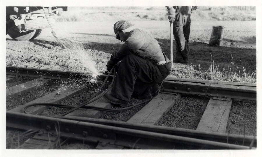 A photograph of Herb Banks cutting a groove into the rail of the roundhouse track after they tried to jump engine 4 over it and it wouldn't jump.