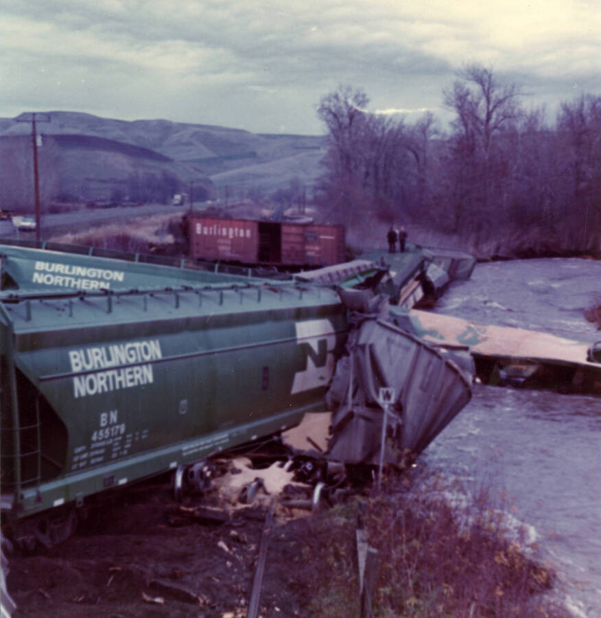 A photograph of the wreckage of M.P. Train 2.5 near Lapwai, costing $5500 in damages. There are several people in the photograph that appear untouched by the crash.