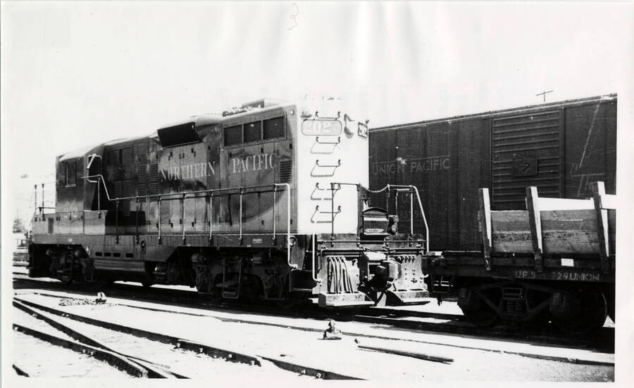 A black and white photograph of the Lewiston Train Yard in Lewiston, ID. The photo shows several stationary train cars on different tracks. The foremost car is the front of a train, and is 'among the first diesel [engines] assigned to CP'.