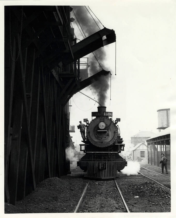 A photograph of train engine #1506 taking sand by the coal dock in the East Lewiston Train Yard.