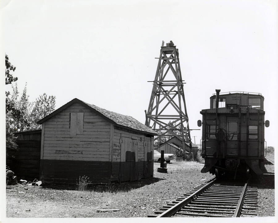 The caboose of train 858 sits opposite the old water pump house and well derrick at Reubens at the top of the grade. While the water tank was removed, these two relics of the steam era still stand in 1976.