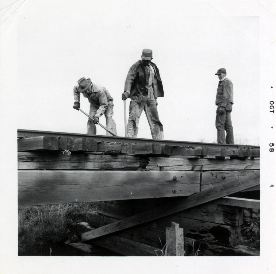 A photograph of several railroad workers cleaning up a newly built railroad.