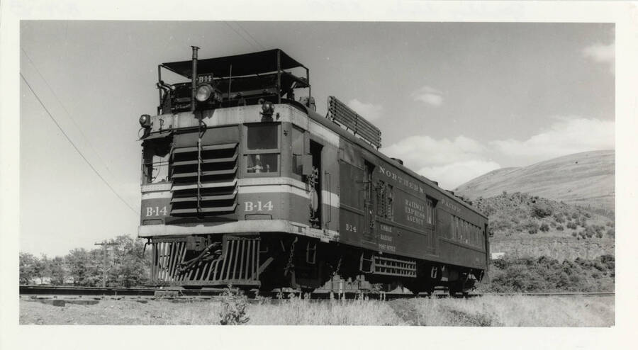 Northern Pacific B-14 railway post office locomotive stopped on railroad tracks.