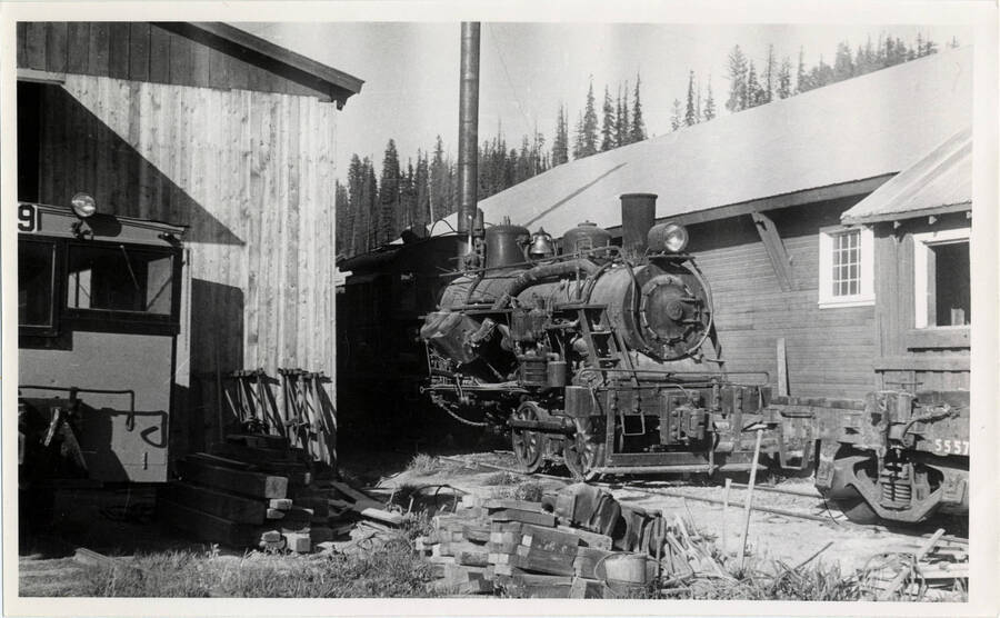 A photograph of Heisler 92 train engine standing serviceable near shop building.