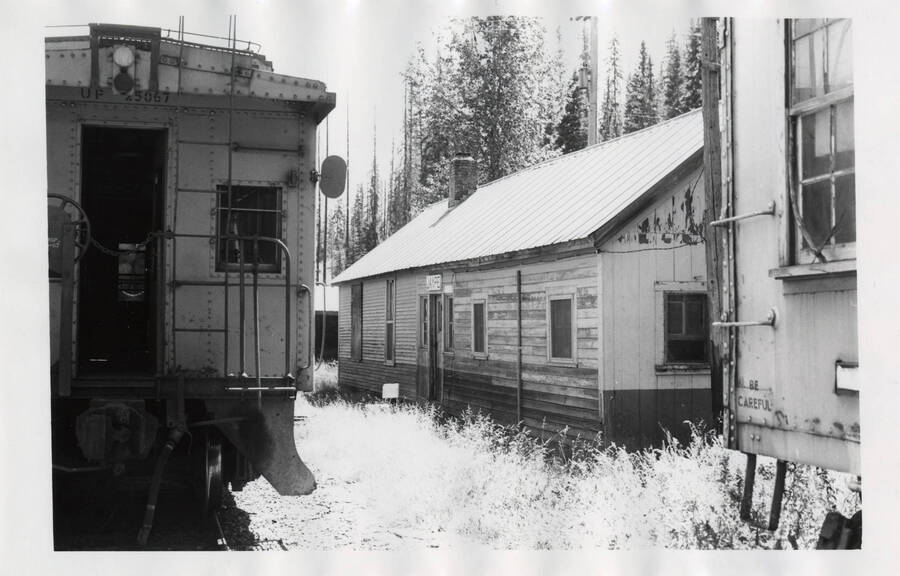 The depot and agent's quarters at Jaype on the Headquarters branch as seen between the caboose of the Headquarters Logger and a UP outfit car.