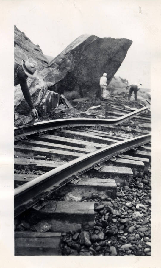 A photograph of the damage to newly laid railroad tracks in the aftermath of a granite rock slide.