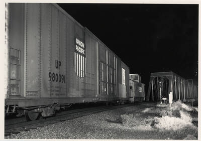 Union Pacific freight train No. 3154 passing over a bridge at night.