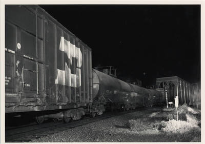 Union Pacific freight train No. 3154 passing over a bridge at night.