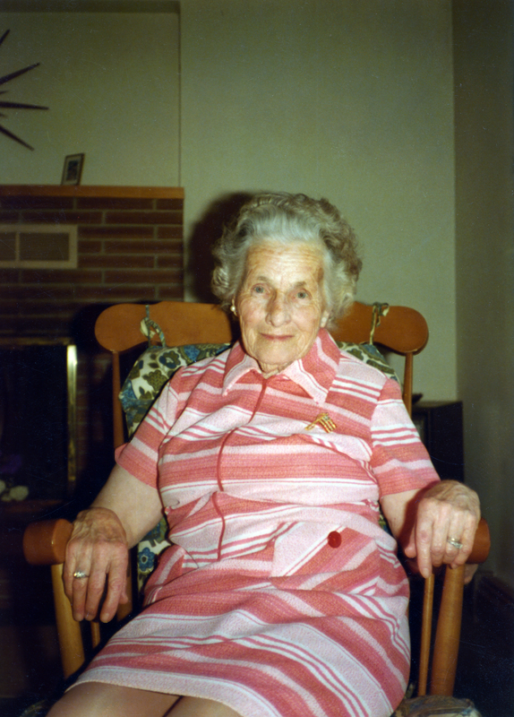 Photograph of Anna Brebner seated, smiling at the camera.