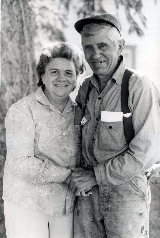 Photograph of Mary Alice Brock and her husband, standing outdoors, smiling at the camera.