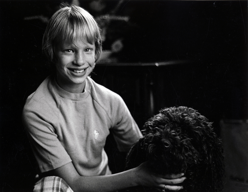 Photograph of Eilene Eliza Darling smiling at the camera, holding a dog.