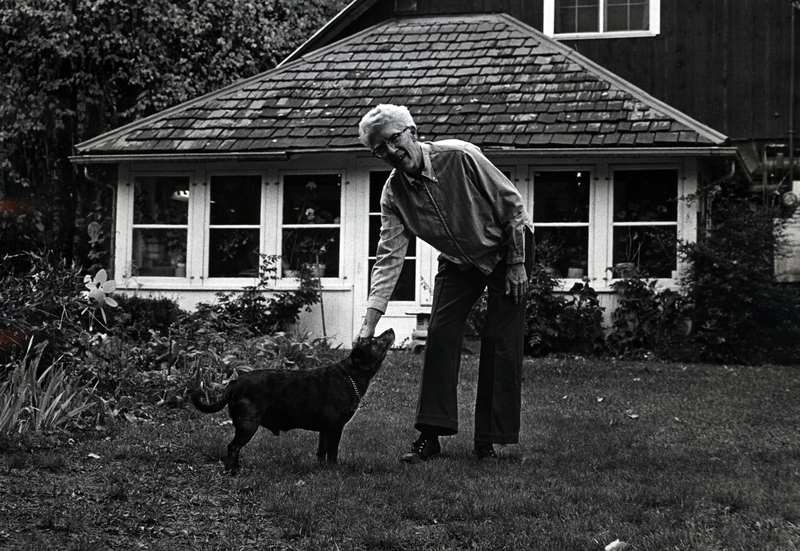 Photograph of Mildred Siegel standing outside with a dog.