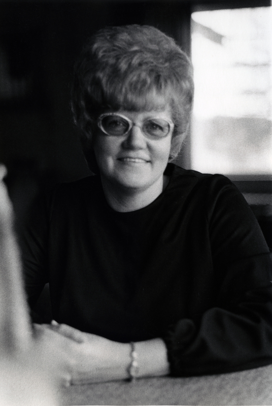 Photograph of Patti Walters seated, smiling at the camera.