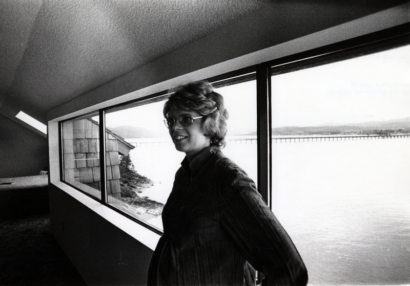 Photograph of Jana Shields standing in front of a window, smiling away from the camera.