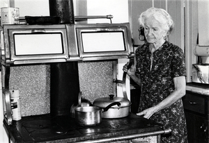 Photograph of Agnes Hailey Jones standing at a kitchen stove.