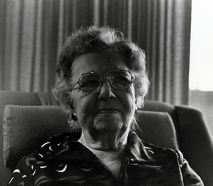 Photograph of Elsie Nelson seated, smiling at the camera.