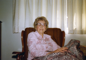 Photograph of Mae Sibley seated, smiling at the camera.