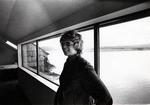 Photograph of Jana Shields standing in front of a window, smiling away from the camera.