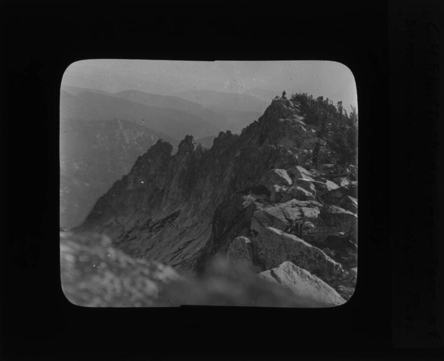 The glass slide reads: 'C. H. Shattuck on mountain of the same name over Blodgett Pass.'