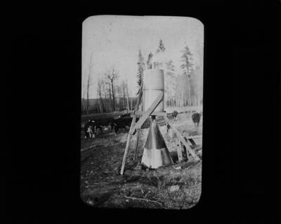 The glass slide reads: 'Hood and condenser used in burning stumps and saving by-products. See Bull #91.'