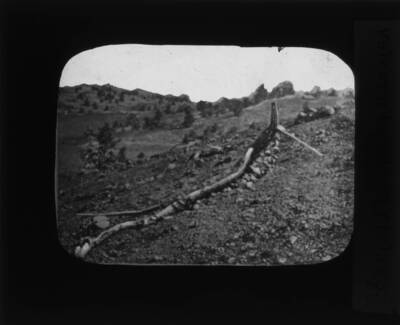 The glass slide reads: 'Volcanic bomb 13 ft. long.'