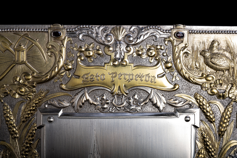 Close up detail of jewelry box cover featuring golden relief of scroll that is etched with the words "Esto Perpetua" (Let it be perpetual) which is the state motto of Idaho. 