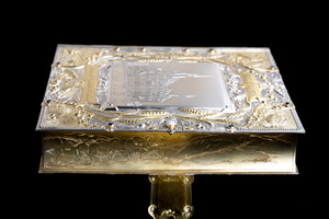 Top lid of jewelry box photographed from an angle to see long edge of box and clasp.